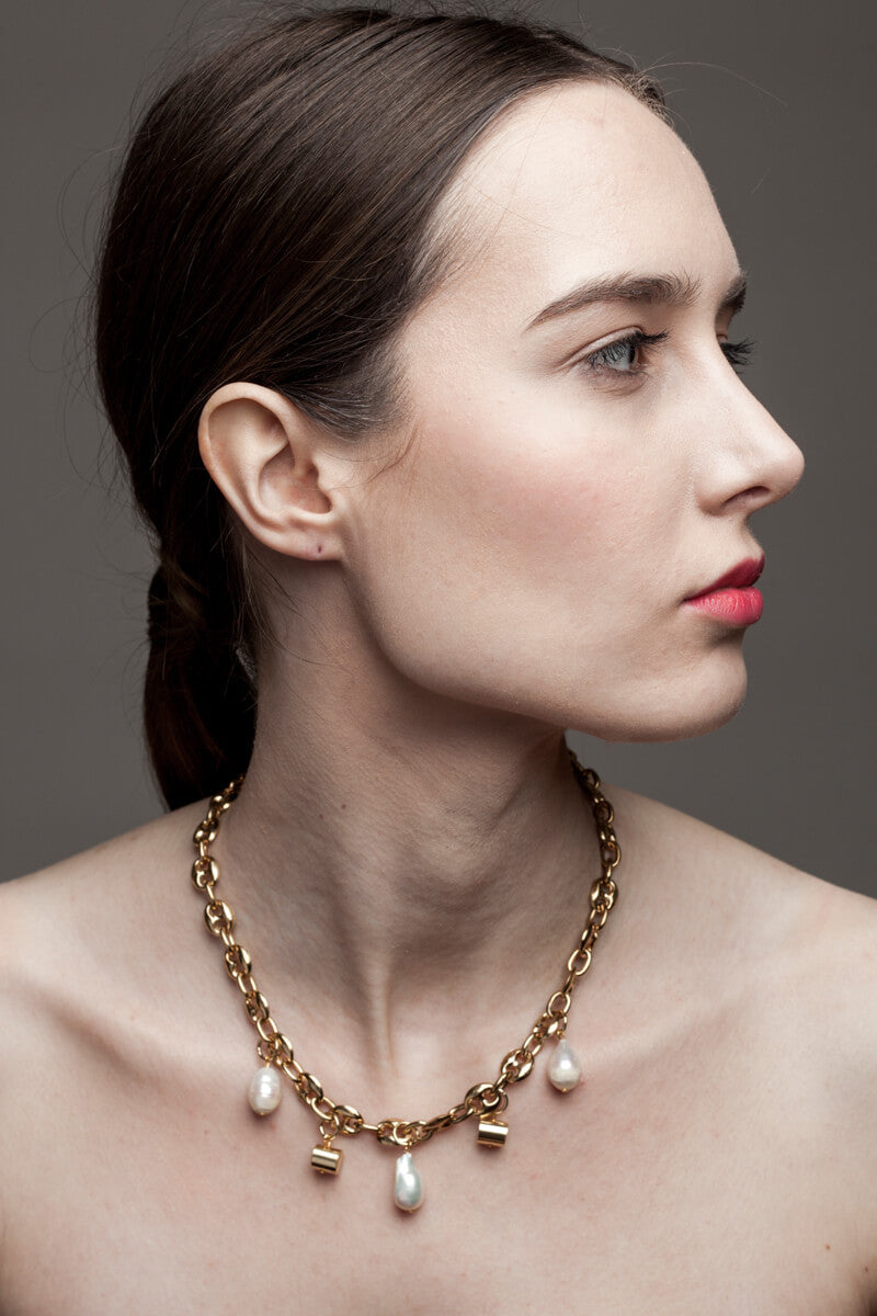 This necklace features 24K gold-plated chain called coffee beans chain and hand cut and 24K gold-plated brass and freshwater pearls.