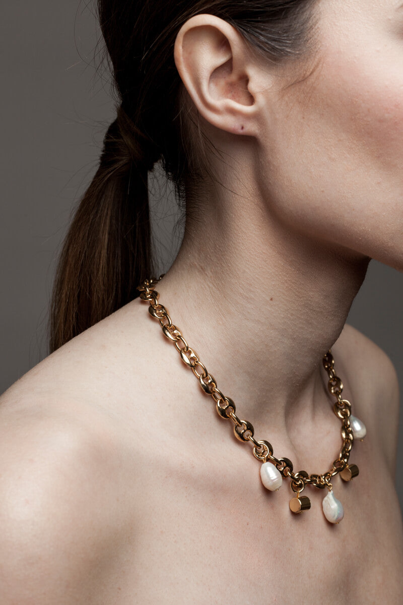 This necklace features 24K gold-plated chain called coffee beans chain and hand cut and 24K gold-plated brass and freshwater pearls.