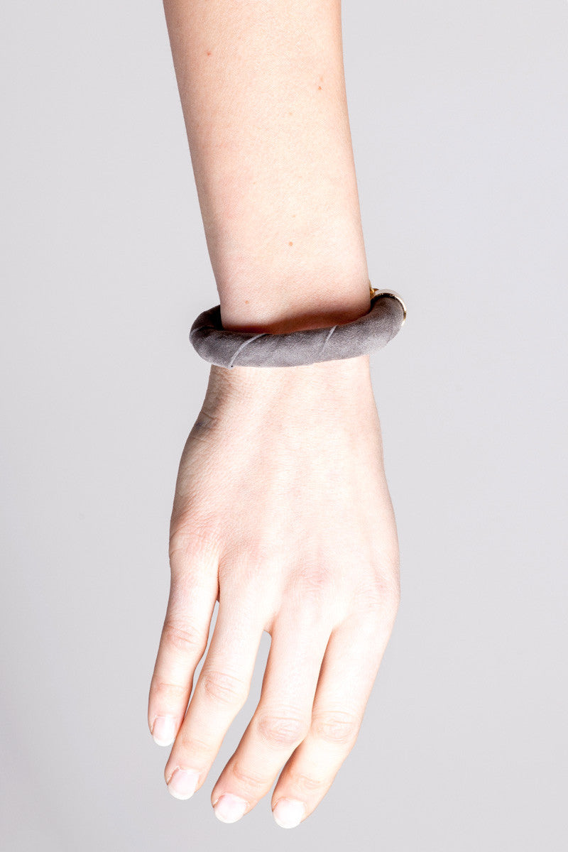 The no. 3 edition of the handcuff bracelet is made of anthracite gray suede with galvanized metal components and quartz. Gold edition.