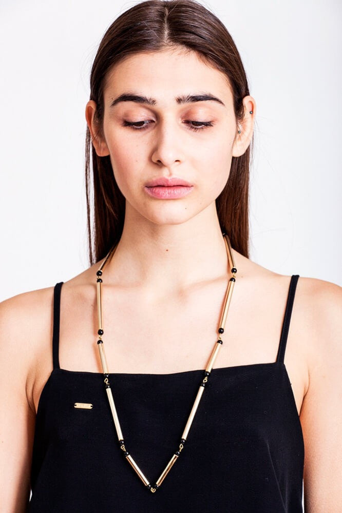 Hidden lines gold edition made of hand-cut, hand polished and galvanized brass featuring black onyx.
