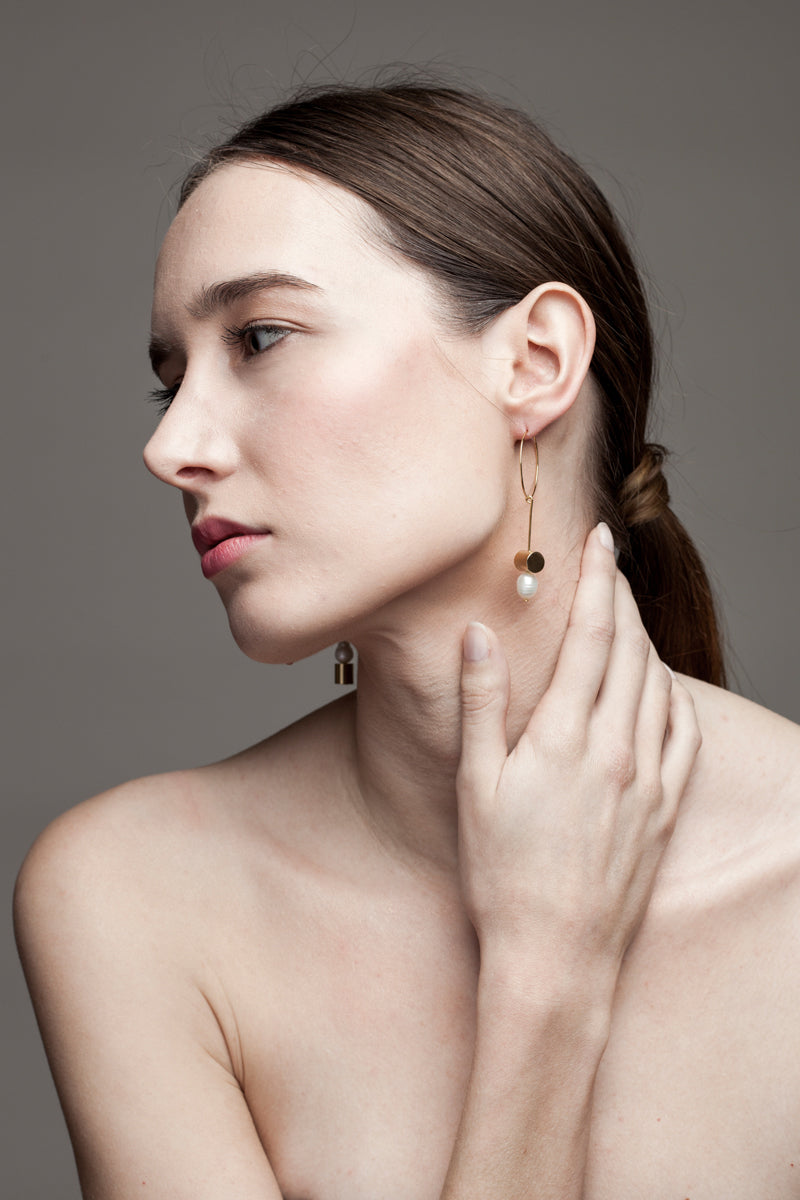 This pair of earring is made of a hoop earring which features 24K gold-plated brass and detachable pendant made of 24K gold-plated brass and freshwater pearl.