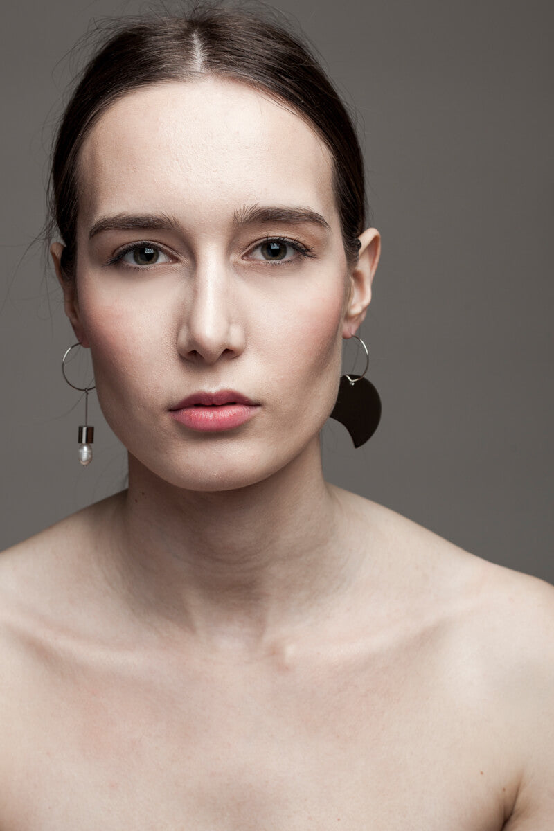 Earrings made of hand cut and galvanized brass and freshwater pearl.