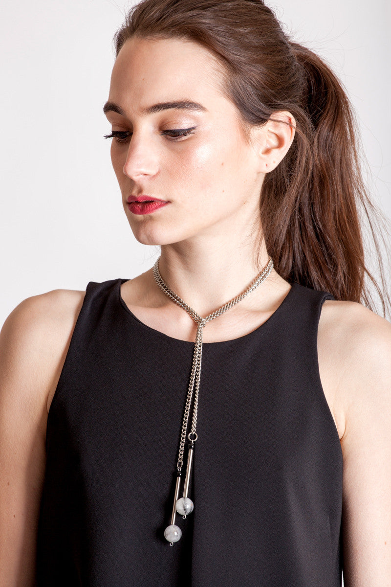 The Bellevue necklace features hand-cut and galvanized brass, onyx, rutilated quartz and galvanized chain.