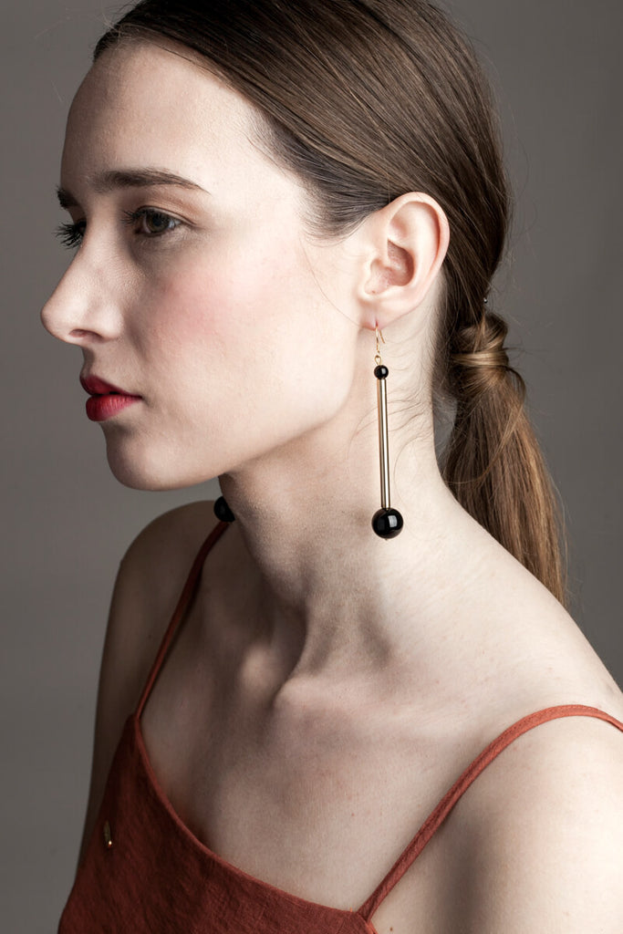 Earrings made of hand-cut, hand-polished and 24K gold-plated brass, onyx and gold plated sterling silver.