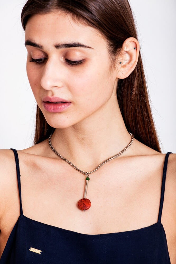 This cute as a button necklace is made of hand-cut and galvanized brass, red coral, jade and galvanized metal componets.