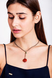 This cute as a button necklace is made of hand-cut and galvanized brass, red coral, jade and galvanized metal componets.