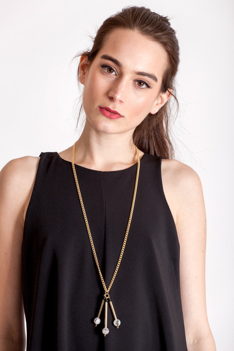 The Elsa necklace is composed of beautiful rutilated quartz, onyx beads and hand-cut and galvanized brass.