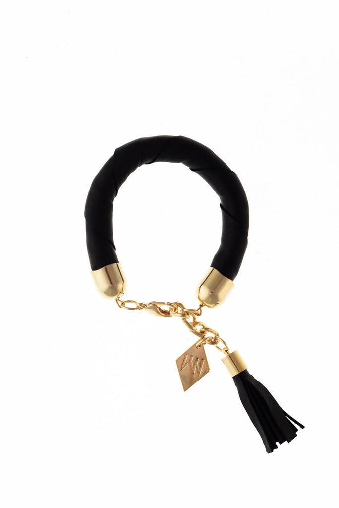 The no. 4 edition of the handcuff bracelet is made of black leather with galvanized metal components and leather tassel. Gold edition. Gold edition.
