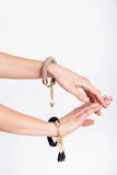 The no. 4 edition of the handcuff bracelet is made of black leather with galvanized metal components and leather tassel.