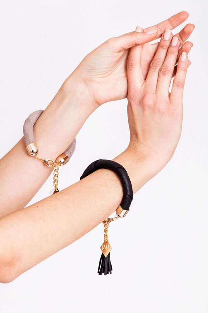 The no. 4 edition of the handcuff bracelet is made of black leather with galvanized metal components and leather tassel.