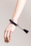 The no. 11 edition of the handcuff bracelet is made of navy blue suede with galvanized metal components with leather tassel. Silver edition.