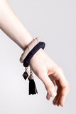 The no. 11 edition of the handcuff bracelet is made of navy blue suede with galvanized metal components with leather tassel. Silver edition.