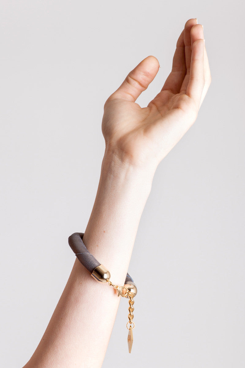The no. 14 edition of the handcuff bracelet is made of leather in copper color with galvanized metal components. Gold edition.