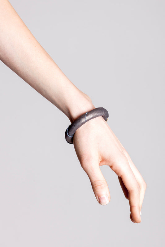 The no. 14 edition of the handcuff bracelet is made of leather in copper color with galvanized metal components. Gold edition.