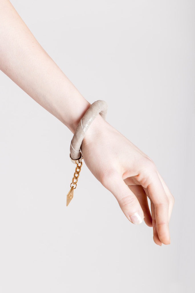 The no. 15 edition of the handcuff bracelet is made of beige suede with silver details and galvanized metal components. gold edition.