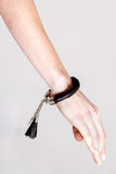 The no. 4 edition of the handcuff bracelet is made of black leather with galvanized metal components and leather tassel. Silver edition. Silver edition.