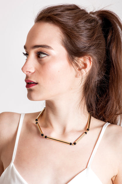 Hidden Lines necklace is made of hand-cut and galvanized brass and onyx.