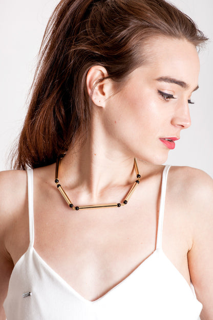 Hidden Lines necklace is made of hand-cut and galvanized brass and onyx.