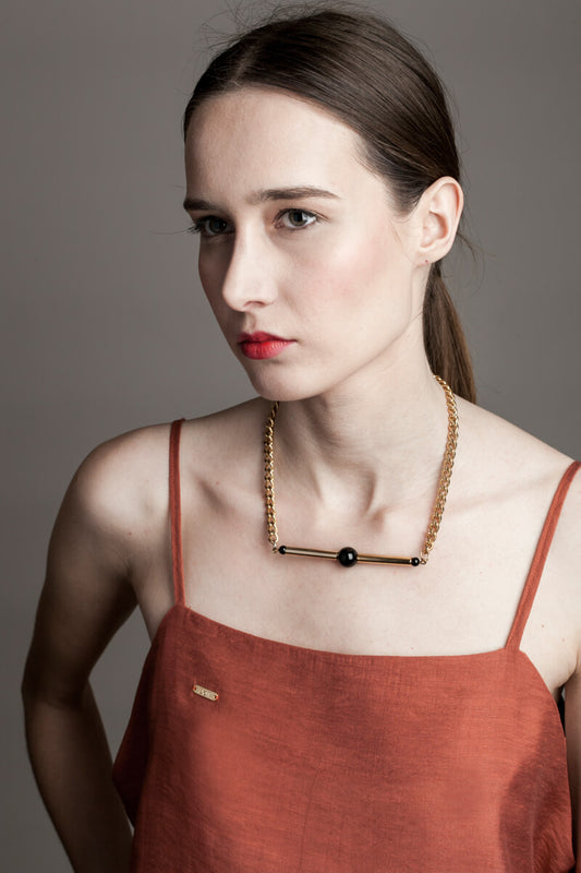 Line necklace made of hand-cut and 24K gold-plated brass, onyx and 24K gold-plated metal components.