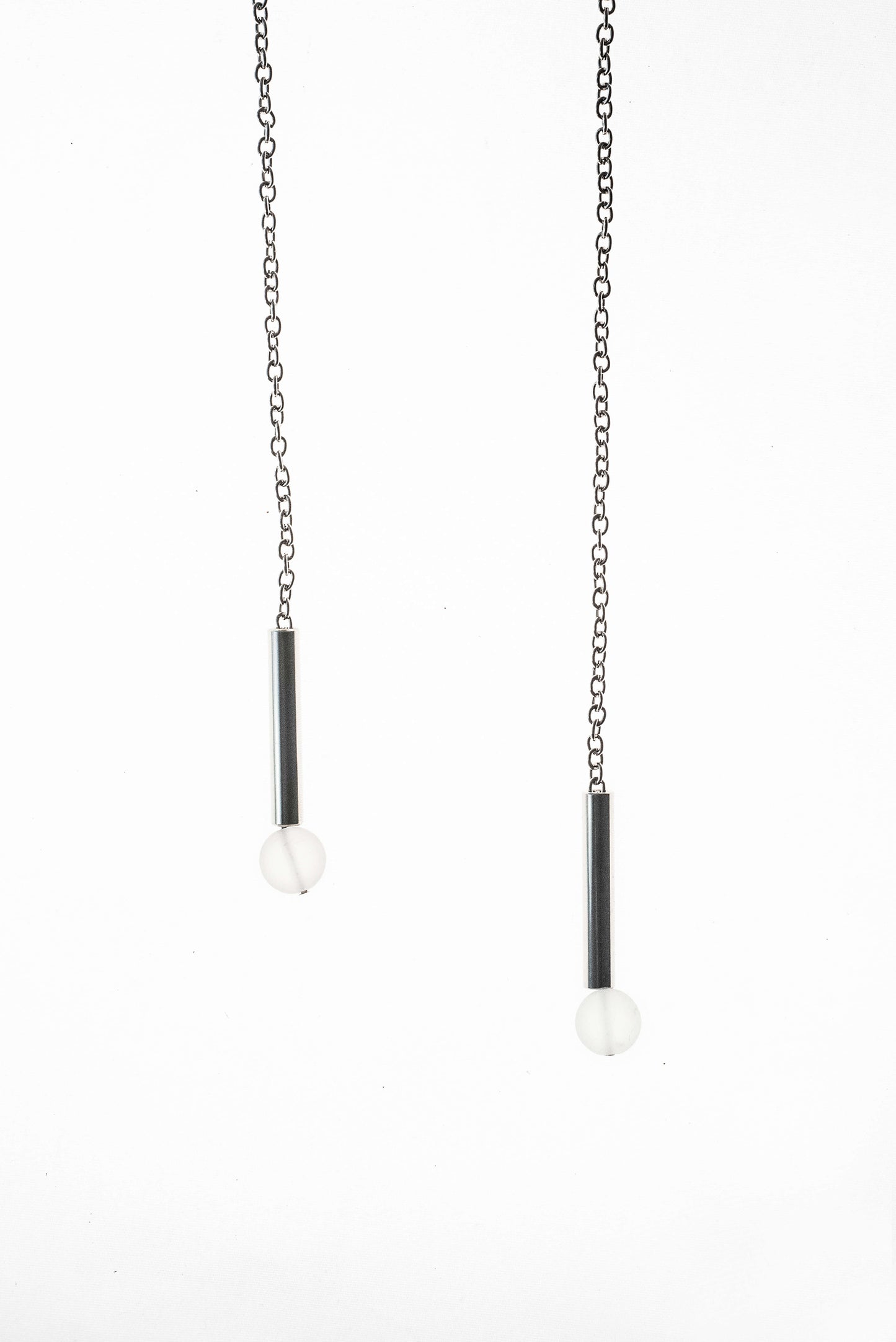 The piece features hand-cut and galvanized brass, quartz and galvanized chain.