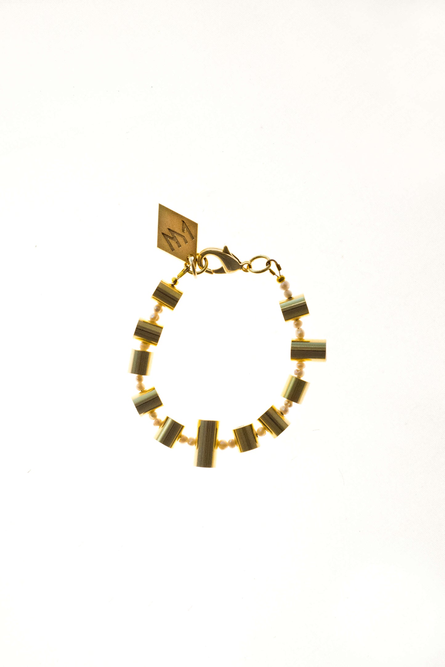 Bracelet features hand cut and 24K gold-plated brass and freshwater pearls.