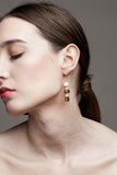 This mismatched earrings are made of hand cut and 24K gold-plated brass, freshwater pearls and gold-plated sterling silver.