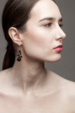 This mismatched earrings are made of hand cut and galvanized brass, onyx and sterling silver.