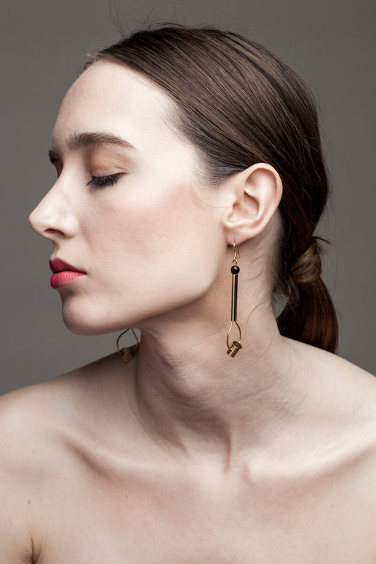 This beautiful statement earrings feature hand cut and 24K gold-plated brass and onyx.