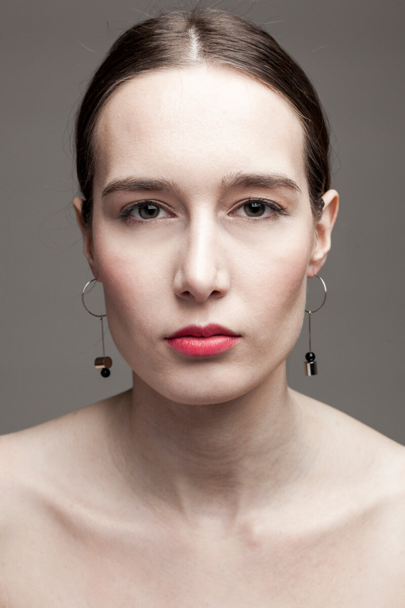 This pair of earring is made of a hoop earring which features galvanized brass and detachable pendant made of brass galvanized in silver and onyx.