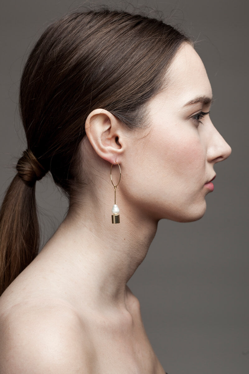 Earrings made of hand cut and 24K gold plated brass and freshwater pearl.