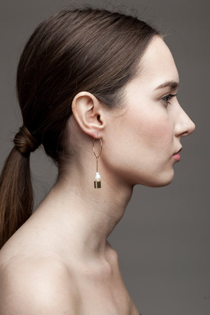 Earrings made of hand cut and 24K gold plated brass and freshwater pearl.