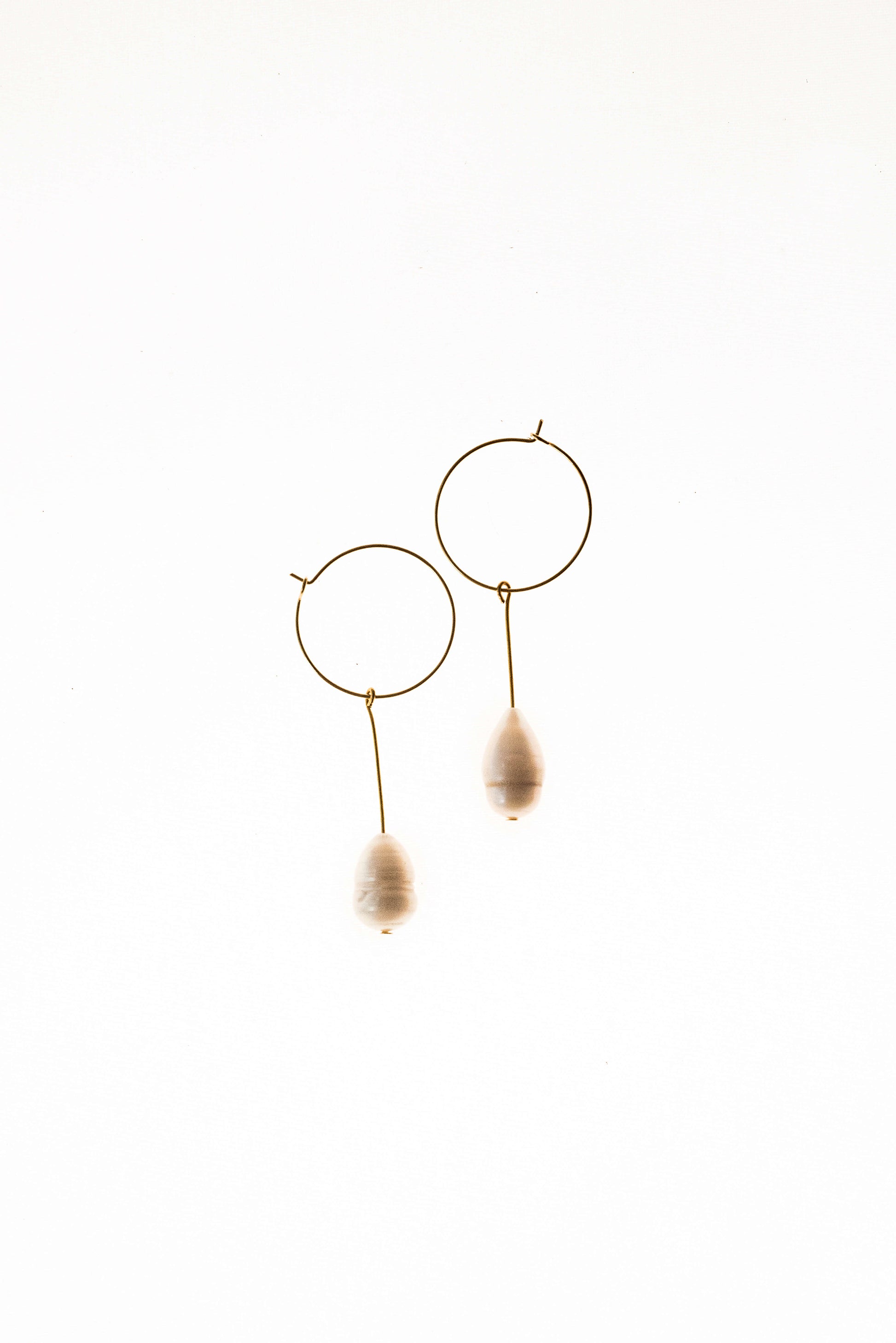 Earrings made of 24K gold plated brass and freshwater pearl.