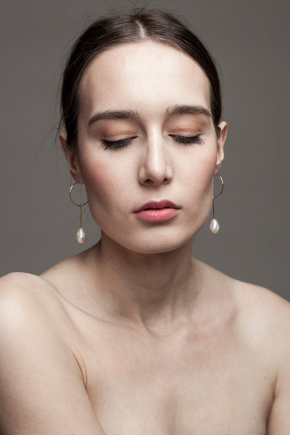 Earrings made of 24K gold plated brass and freshwater pearl.