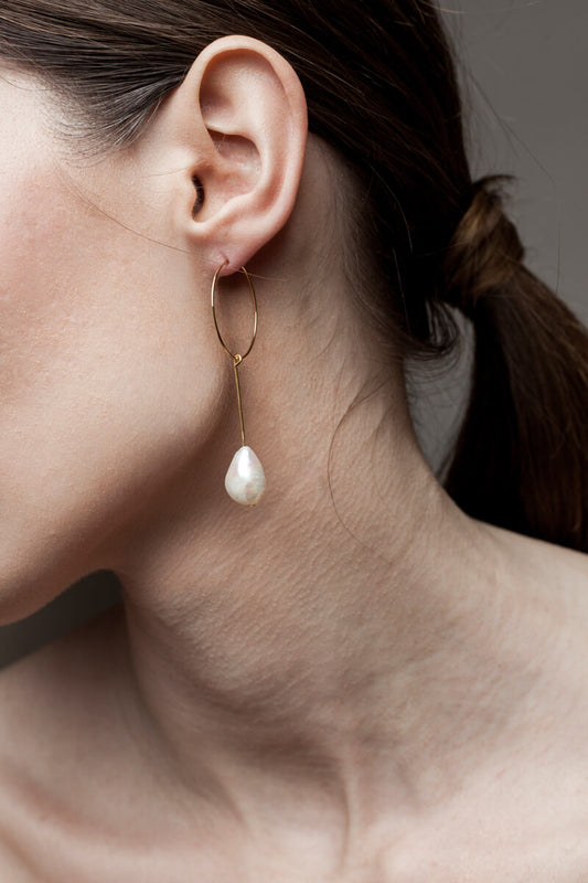 Earrings made of 24K gold plated brass and freshwater pearl.